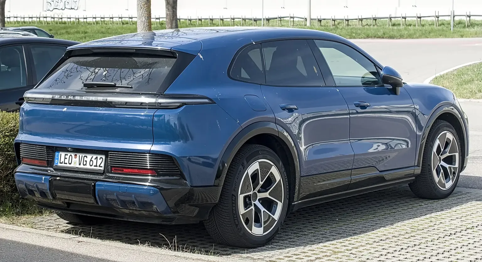 Modré Porsche Cayenne Electric při pohledu zezadu a z boku