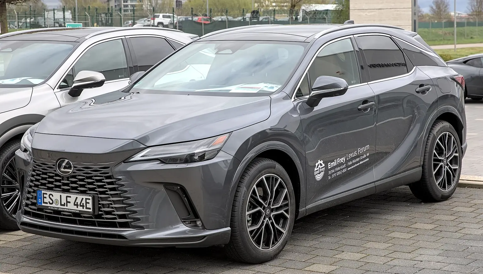 Šedý Lexus RX 450h+ při pohledu zepředu a z boku
