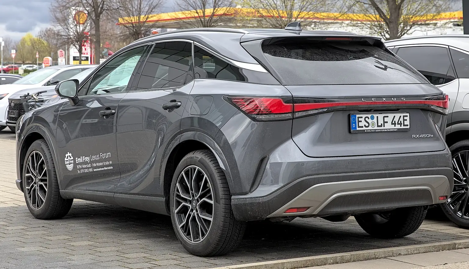 Šedý Lexus RX 450h+ při pohledu zezadu a z boku