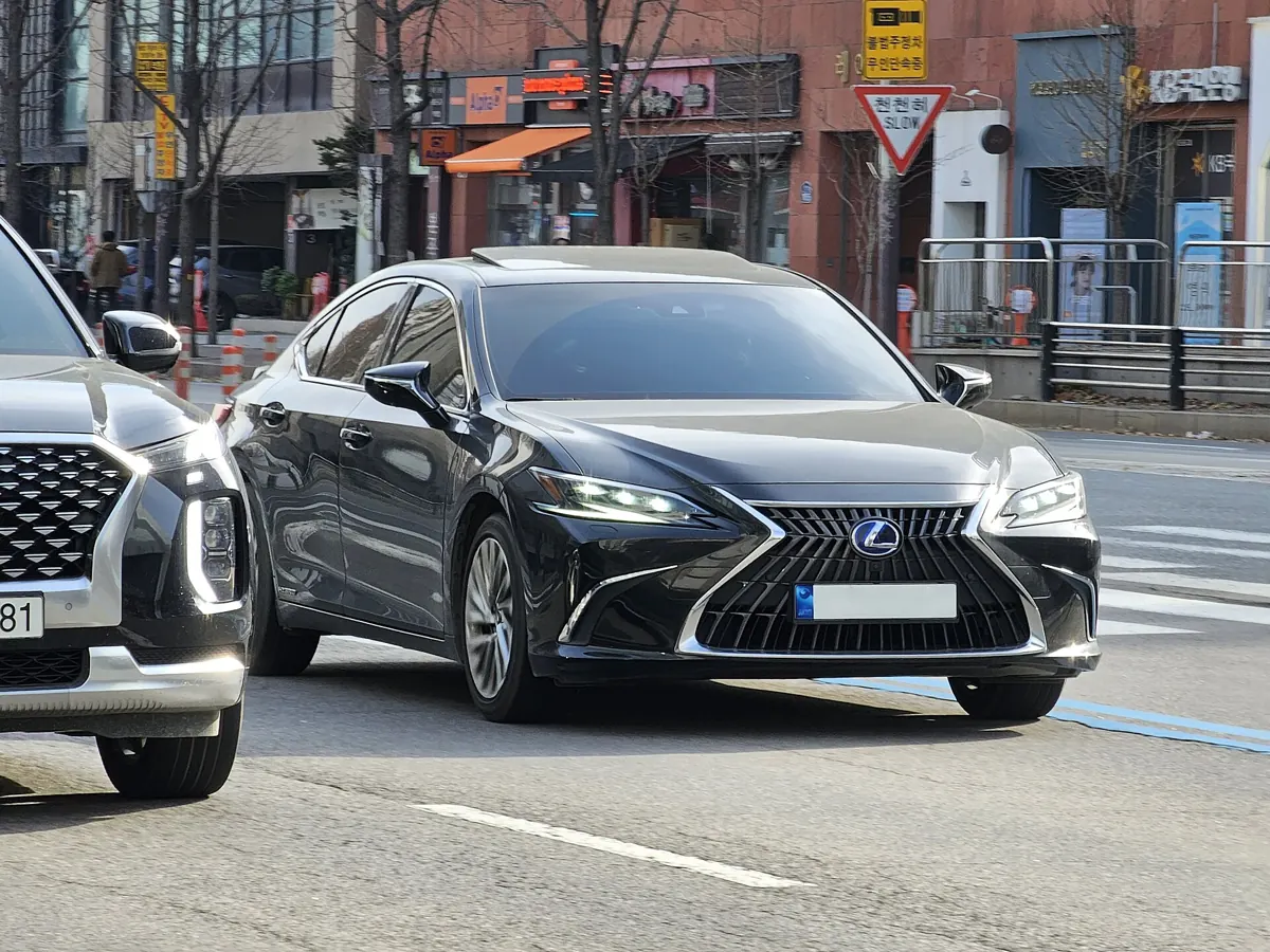 Černý Lexus ES 300h předchozí sedmé generace za jízdy