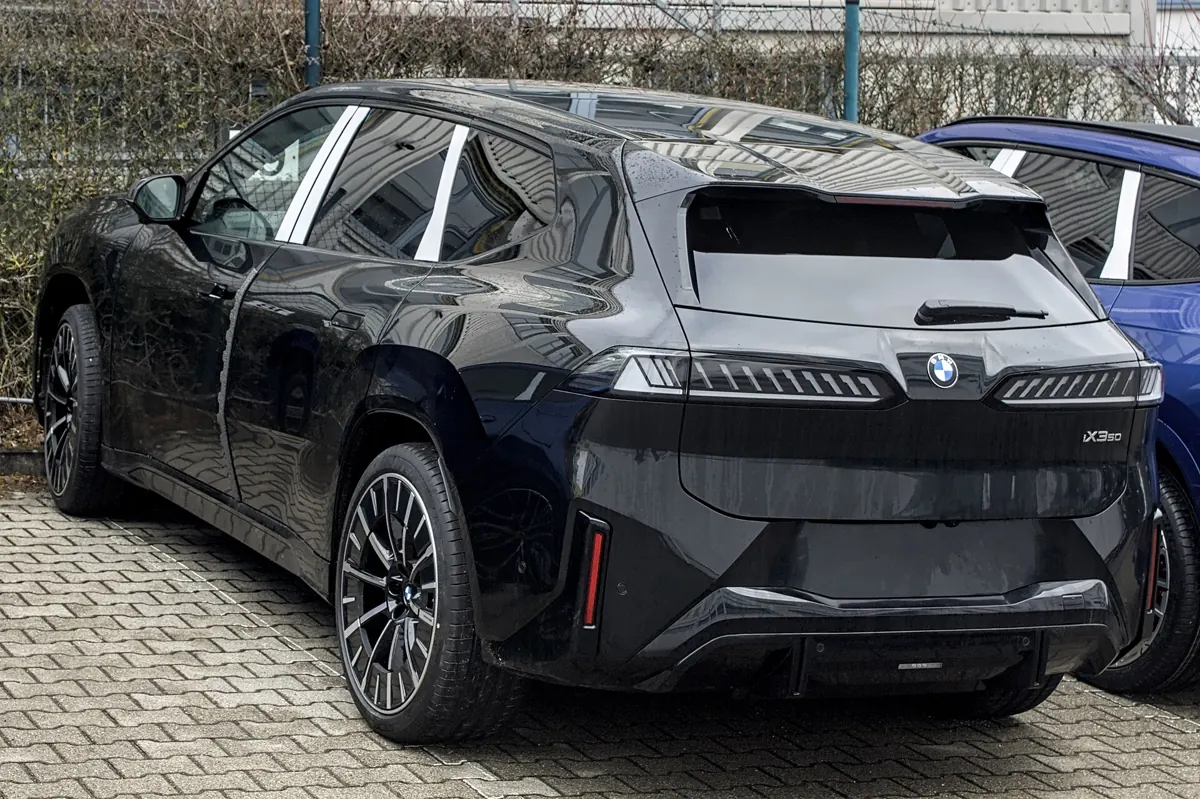 Tmavé BMW iX3 Neue Klasse při pohledu zezadu a z boku