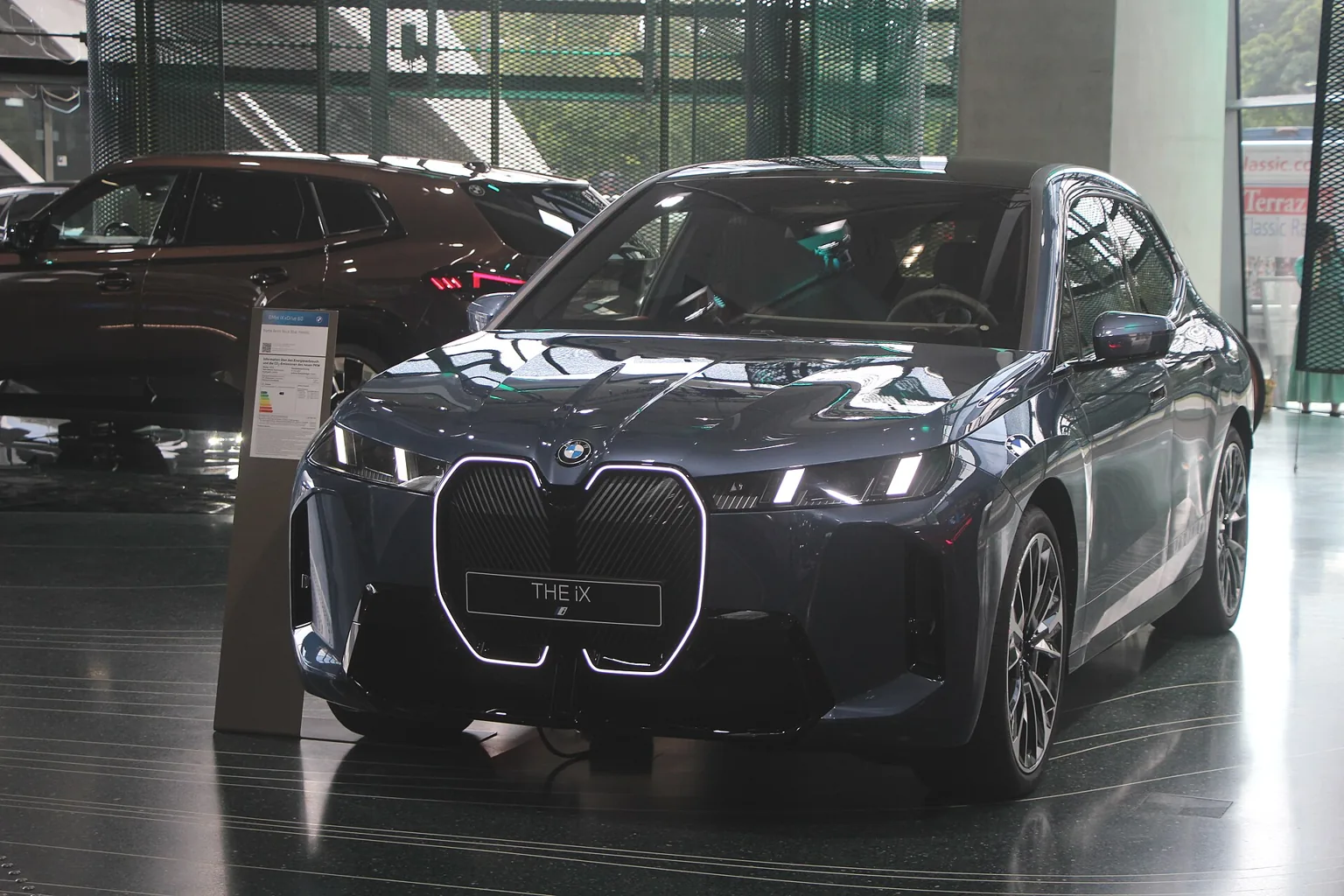 Modernizované BMW iX v tmavém odstínu při pohledu zepředu
