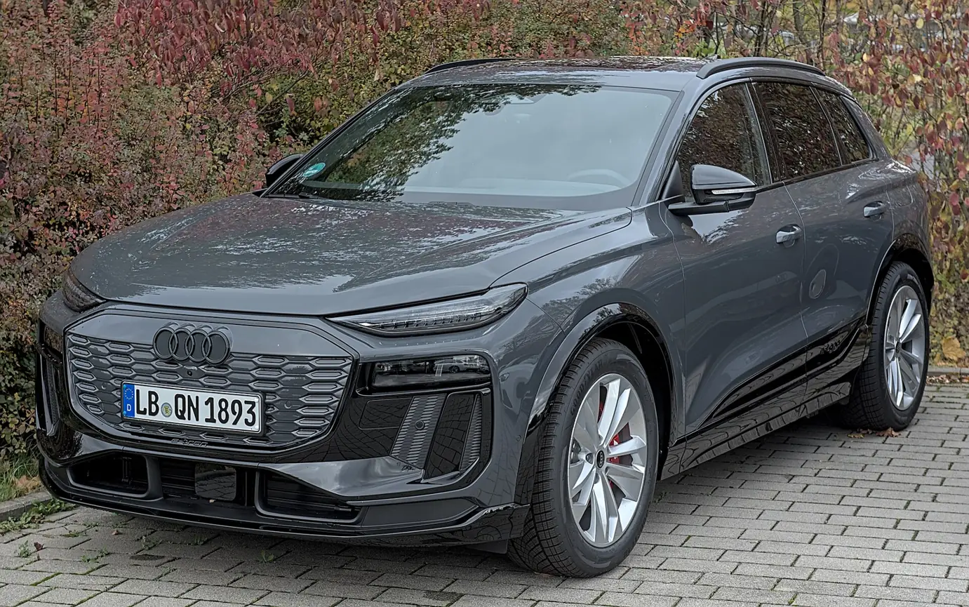 Tmavé Audi Q6 e-tron SUV při pohledu zepředu a z boku