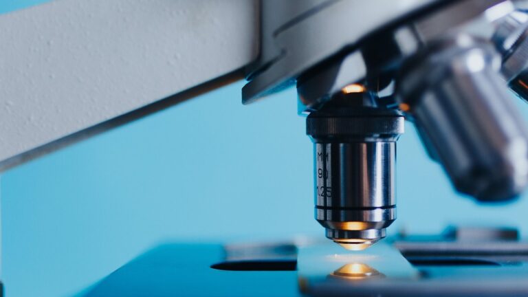 Objektiv laboratorního mikroskopu nad podložním sklíčkem